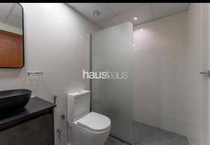 y baño con aseo blanco y lavamanos. en Phineek Studio Apartment The Green Al Alka, en Dubái