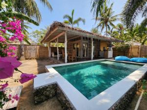 une villa avec une piscine et une maison dans l'établissement Bamboo Lodge, à Gili Trawangan