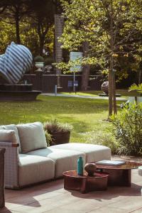 a couch sitting on a patio in a park at MarePineta Resort in Milano Marittima