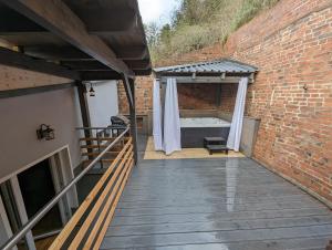 an outdoor deck with a tub in a brick wall at Havel Suites in Havelberg
