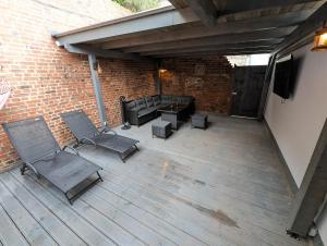 a patio with chairs and a couch on a brick wall at Havel Suites in Havelberg