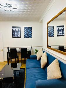 uma sala de estar com um sofá azul e uma mesa em Cosy 3 Bed House - Reading Cent. Free Parking em Reading