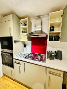 a kitchen with a stove top oven in a kitchen at Cosy 3 Bed House - Reading Cent. Free Parking in Reading