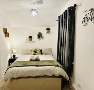 um quarto com uma cama grande e cortinas pretas em Cosy 3 Bed House - Reading Cent. Free Parking em Reading