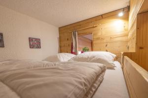 two white beds in a room with wooden walls at Studio Les Saisies in Hauteluce