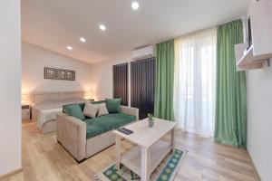 uma sala de estar com uma cama, um sofá e uma mesa em New Tiflis Apartment Plekhanovi em Tbilisi