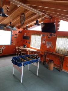 a ping pong table in a room with an orange wall at Hostel Cruz del Sur in Ushuaia