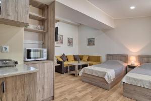 Habitación de hotel con 2 camas y sala de estar. en New Tiflis Apartment Plekhanovi en Tiflis