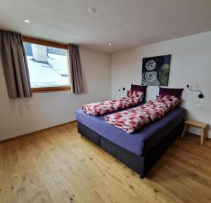 a bedroom with a bed with red pillows on it at Chasa Siringia in Samnaun