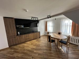 a living room with a table and a tv at Nysa River Apartments Zgorzelec in Zgorzelec