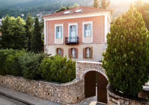 una casa en una pared de piedra con un edificio en Archontiko Parnassus Dadi, en Amfikleia