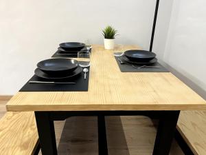 - une table en bois avec deux poêles dans l'établissement Apartamentos Baladrias Formigal Centro - Recién Reformado, à Formigal