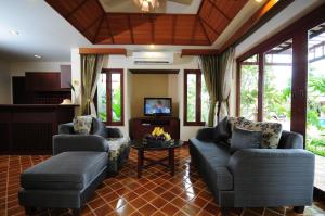 a living room with two couches and a table at Bhumlapa Garden Resort in Bophut