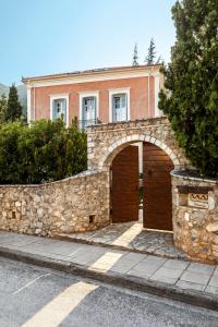 una casa con una pared de piedra y un garaje en Archontiko Parnassus Dadi, en Amfikleia
