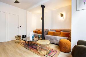 uma sala de estar com um sofá e uma mesa em St Germain-Bon Marché - cosy n°2 em Paris