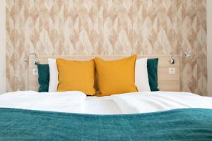 ブダペストにあるプリンス アパートメンツのベッドルーム1室(黄色と緑の枕が付いたベッド1台付)