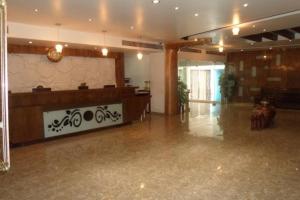 a large lobby with a reception desk in a building at Hotel Maan Residency Satellite Road in Ahmedabad