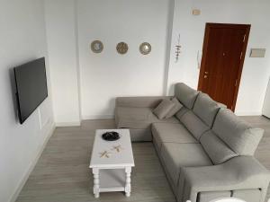 ein Wohnzimmer mit einem Sofa und einem Tisch in der Unterkunft Apartamento 8 mamia costa in Torreguadiaro