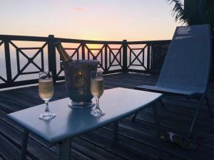 a table with a bottle of champagne and two glasses at Home Ocean 360° in Saint-Leu
