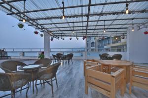 a restaurant with tables and chairs and a balcony at Hotel Highland By DLS Hotels in Mussoorie
