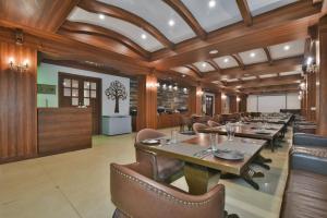 a dining room with wooden ceilings and tables and chairs at Hotel Highland By DLS Hotels in Mussoorie