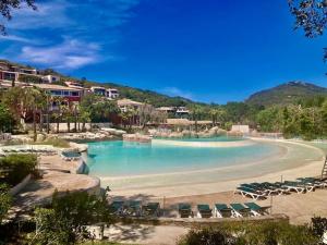 una piscina con sillas y una playa en Les Restanques Cabrière 3123 vue mer 3 chambres, en Grimaud