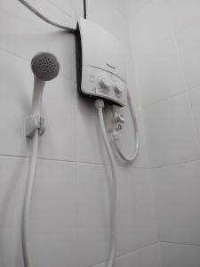y baño con ducha y cabezal de ducha. en WAFID HOMESTAY 2 SERI ISKANDAR, en Seri Iskandar