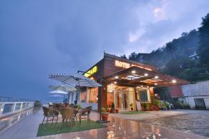 a restaurant with chairs and tables and umbrellas at Hotel Highland By DLS Hotels in Mussoorie