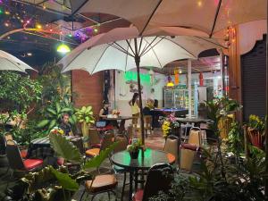 a restaurant with tables and chairs and an umbrella at Chai Ben guesthouse in Jomtien Beach