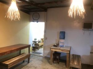 a room with two benches and two tables and lights at Elmo’s place in El Nido