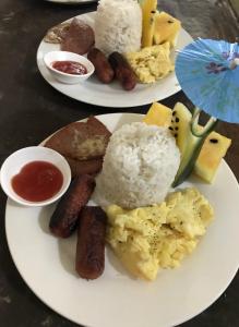 dos platos de comida en una mesa con arroz y salchichas en Elmo’s place, en El Nido