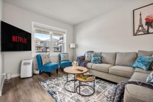 a living room with a couch and a table at Newly Built Family Townhome, Sleeps 12 Comfortably in Airdrie