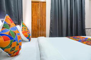 a bedroom with two beds with colorful pillows at FabHotel Skyline I in Méribel Village