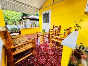 a yellow room with two chairs and a table at Debzyph Happy Home in Castillejos