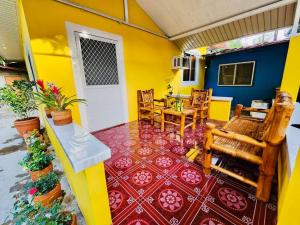 a room with a yellow house with a table and chairs at Debzyph Happy Home in Castillejos