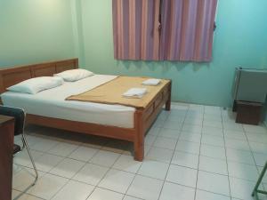 um quarto com uma cama com duas toalhas em โรงแรมพรถวิล ศรีสะเกษ Sisaket PonTaWin Budget Inn em Si Sa Ket