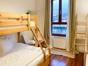 1 dormitorio con 2 literas y balcón en Refugio noruego, en Bilbao