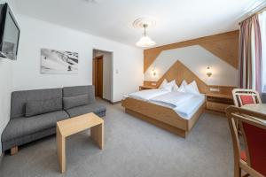 pokój hotelowy z łóżkiem i kanapą w obiekcie Pension Bergfrieden w mieście Obergurgl