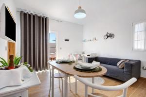 a living room with a table and a couch at Apartamento El Naranjo con jacuzzi in Tarajalejo