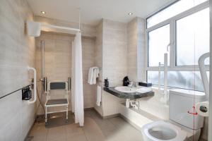 a bathroom with a toilet and a sink and a window at President Hotel in London