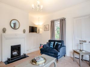 a living room with a blue couch and a fireplace at South Lodge- Uk45600 in Southwell