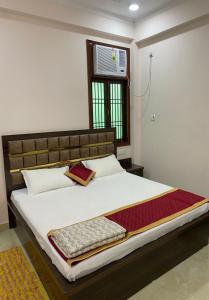 a bedroom with a bed with a tv on the wall at Shri Ram Paying Guest House in Varanasi