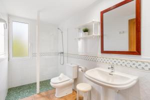 a bathroom with a toilet and a sink and a mirror at Villa Libra in Cala en Forcat +34 photos