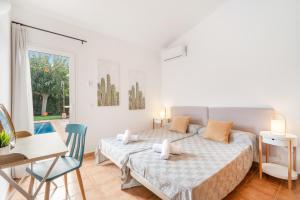 a bedroom with a bed and a table and a chair at Villa Libra in Cala en Forcat