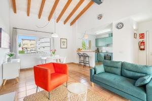sala de estar con sofá verde y silla roja en Villa Libra, en Cala en Forcat