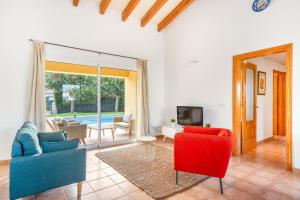 sala de estar con 2 sillas y TV en Villa Libra, en Cala en Forcat