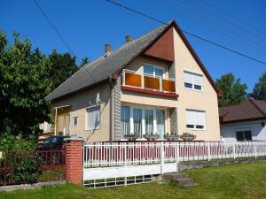 uma casa com uma cerca branca em frente em Großes Ferienhaus in Fonyd mit Großer Terrasse em Fonyód