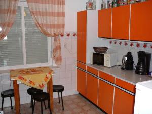 uma cozinha com armários laranja e uma pequena mesa em Großes Ferienhaus in Fonyd mit Großer Terrasse em Fonyód