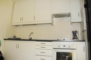 a kitchen with white cabinets and a sink at Arbousiers in Morcenx