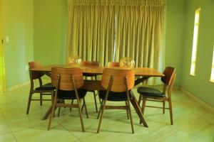 a dining room with a wooden table and chairs at La Maison Guesthouse in Thohoyandou